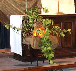 The 'camp fire' is on a stool, with leafy branches arranged round it